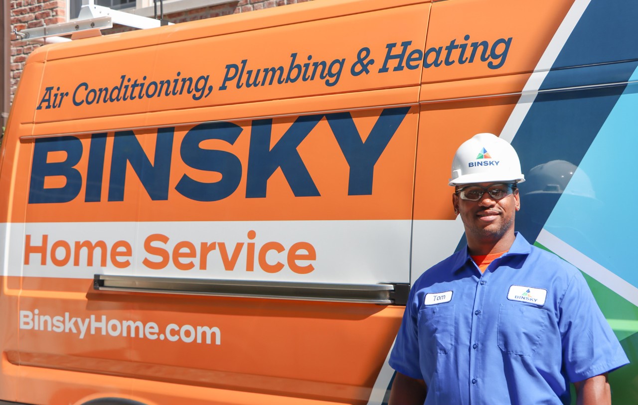 Binsky Home Service Technician in front of a service van