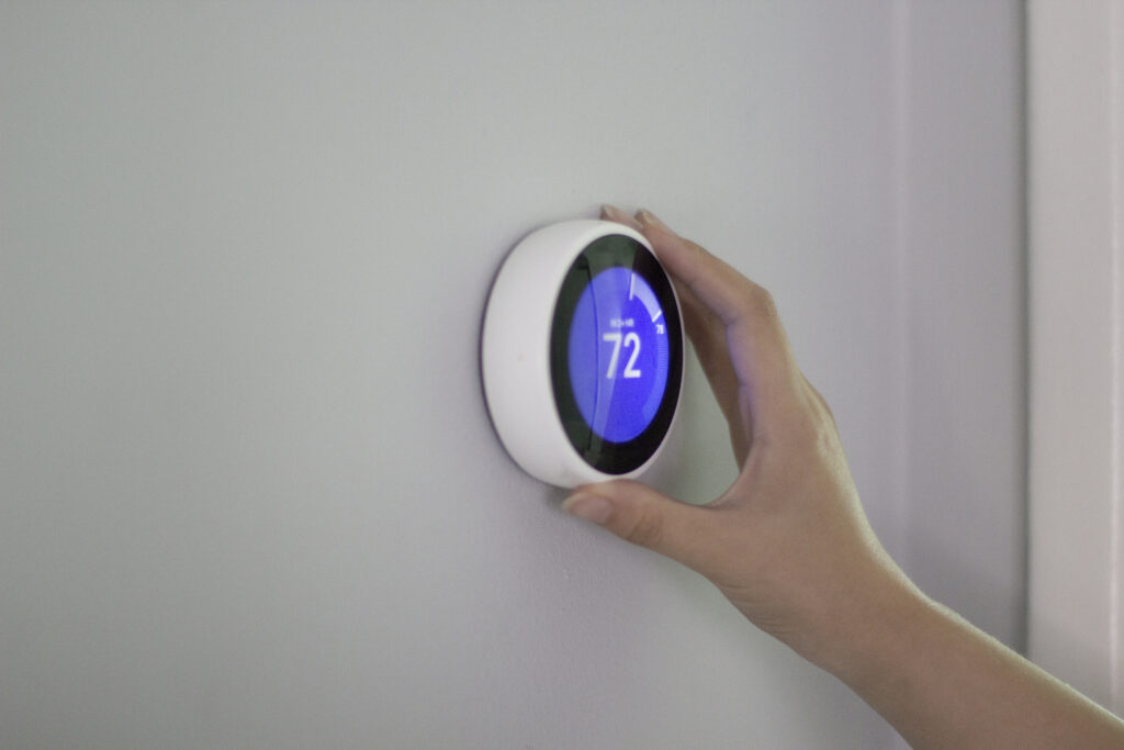 Person using smart thermostat that's set to 72