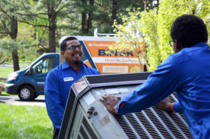 Binsky Home Service team members carrying an AC unit..