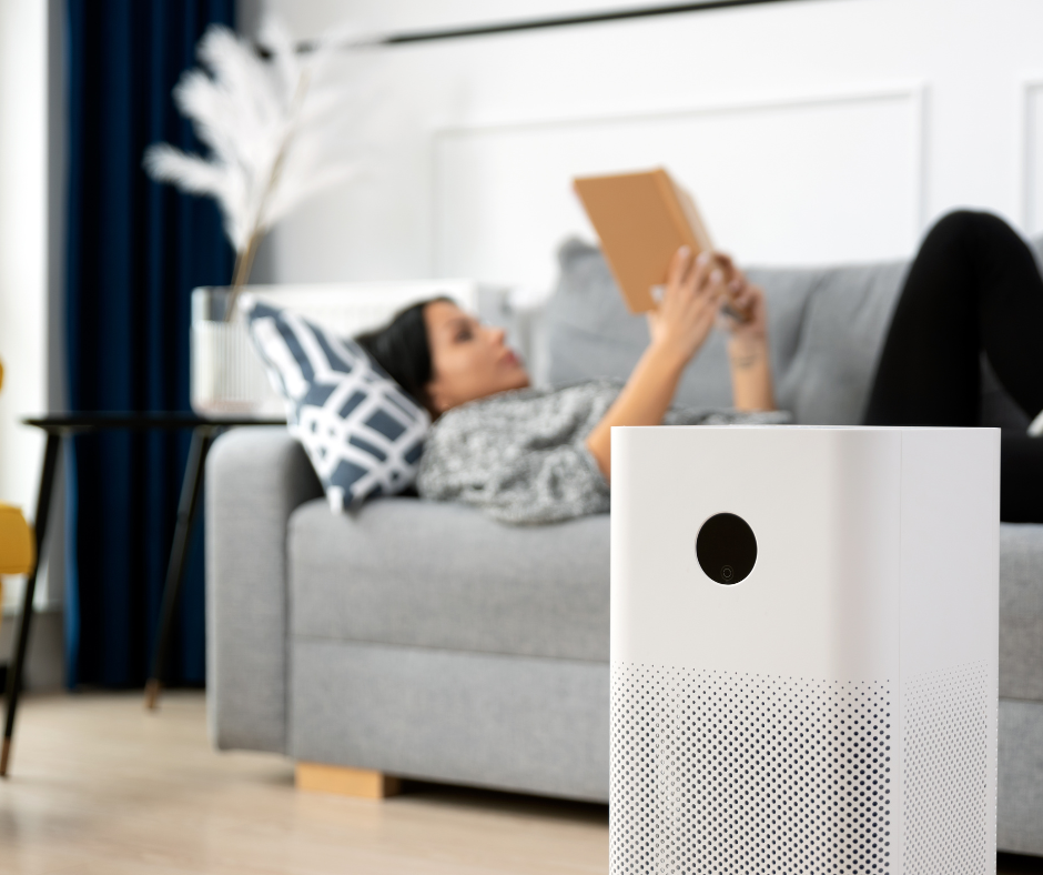 Woman laying on the couch in her home with an air purifier nearby.